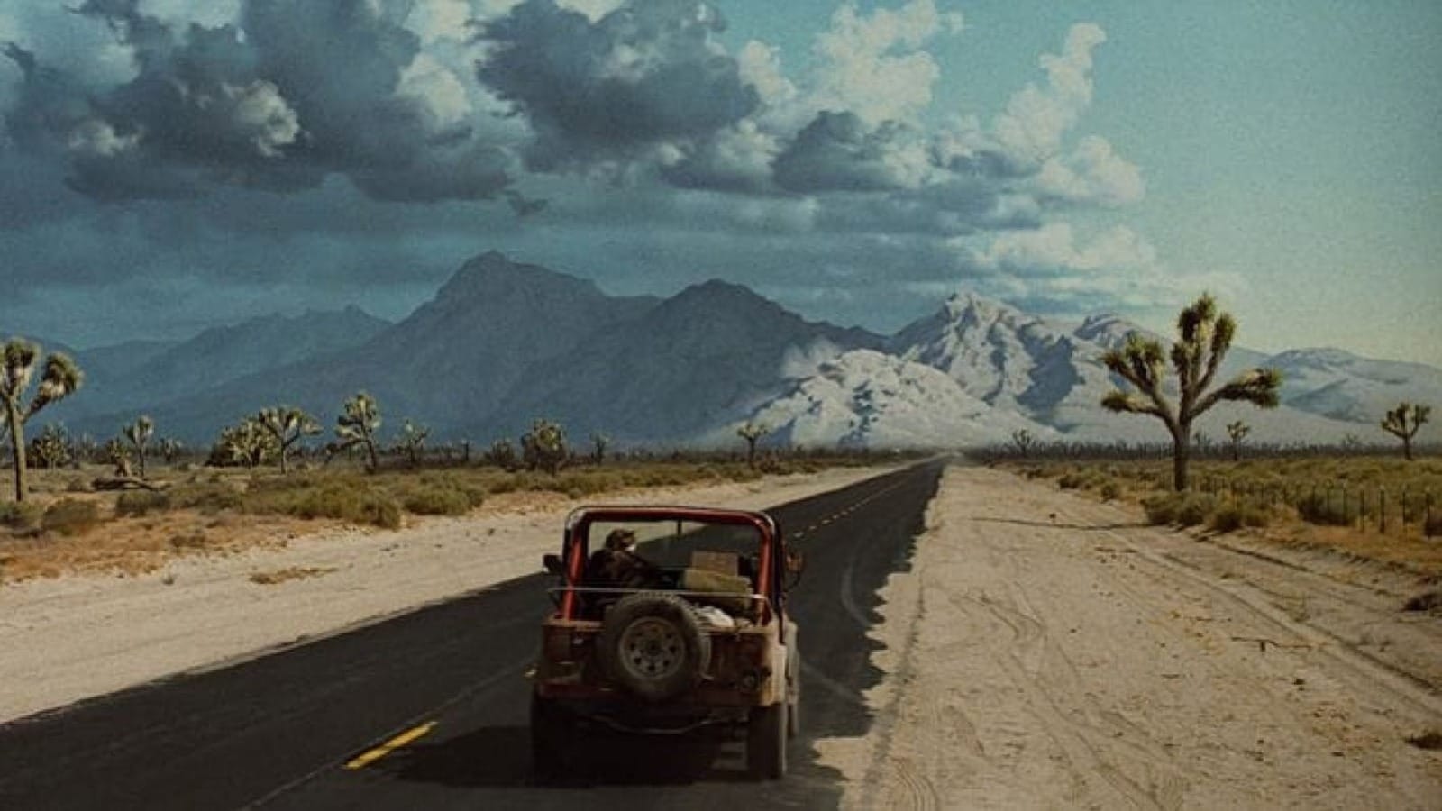 End scene of The Terminator. Sarah Connor drives a jeep towards mountains with clouds gathering above..