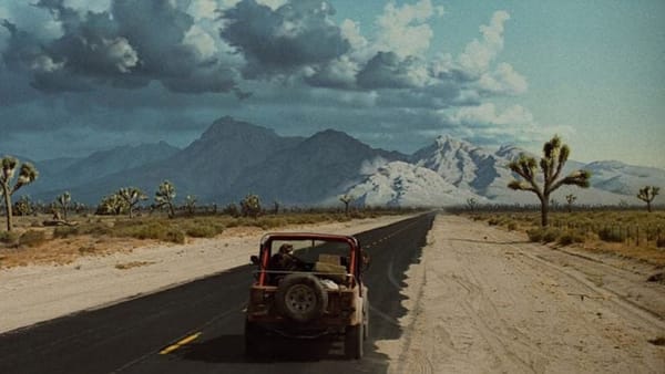 End scene of The Terminator. Sarah Connor drives a jeep towards mountains with clouds gathering above..